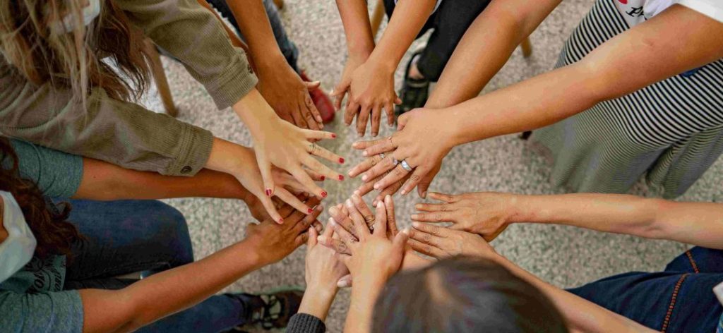 Nonprofit Start women inspiring change all hands together in the center