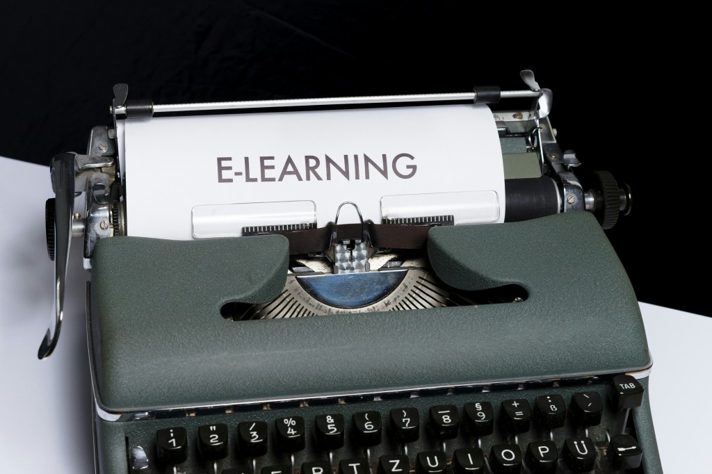 Old-fashioned typewriter with paper stating,  "e-learning" for Nonprofit Start's free grant writing classes. 